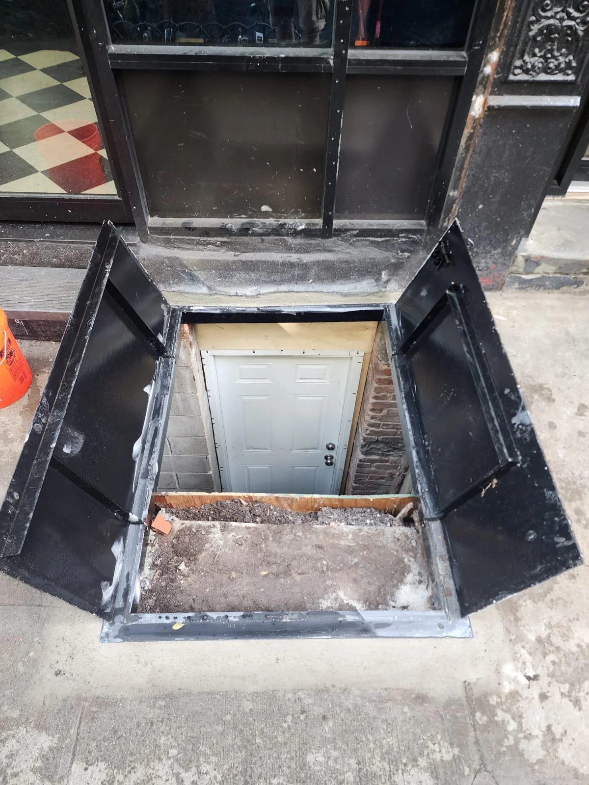 Open black sidewalk cellar door 